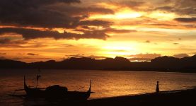 sundown at Balayan Bay, light clouded, brown to orange teint, traditional philippine fishing boat to the left and a little girl with a fishing net enjoying the view, the water has tiny waves and looks like a aged copper plate, the sun submerged behind the ridge of smal mountains.